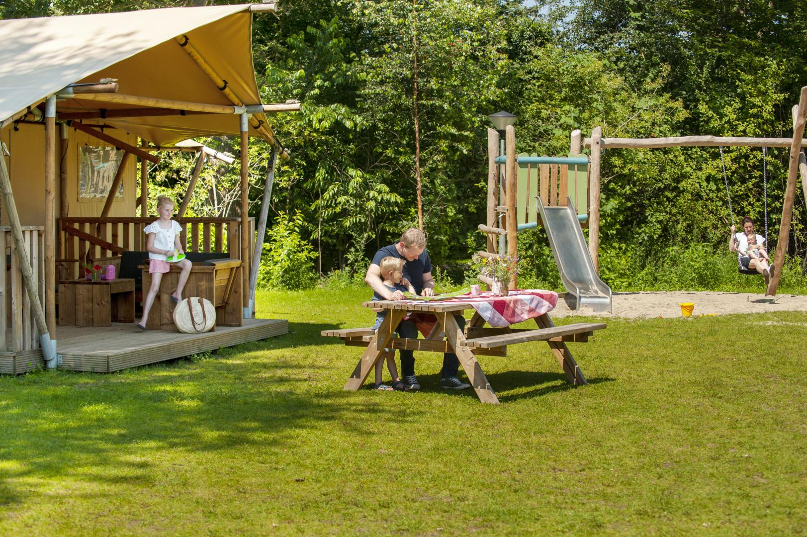 een gezin die kampeert in een stacaravan gelegen direct naast de speeltuin